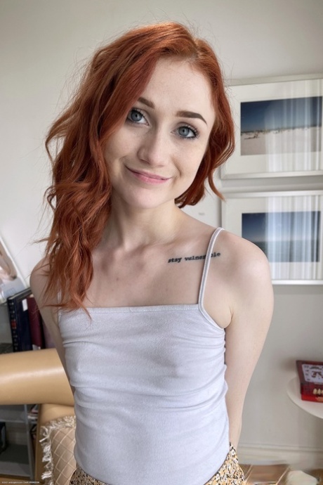 Redheaded teen with a tasty hole Scarlet Skies lifts her skirt up and poses