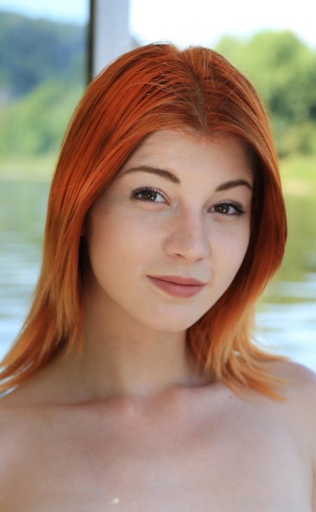 Stunning redheaded babe Nessie Blue shows her big booty and boobs outdoors