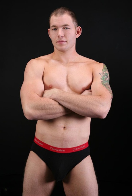 Sexy short haired gay Tex shows his stiff dick and poses naked on a couch