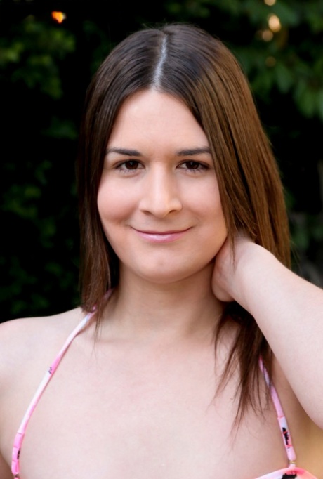 Brunette shemale Ashley Washington flaunts her dick, tits and poses poolside