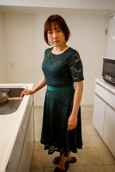Asian housewife Yuki Kozakura shows her shaved pussy in the kitchen