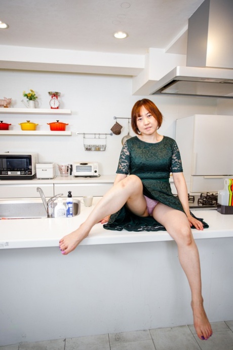 Asian housewife Yuki Kozakura shows her shaved pussy in the kitchen