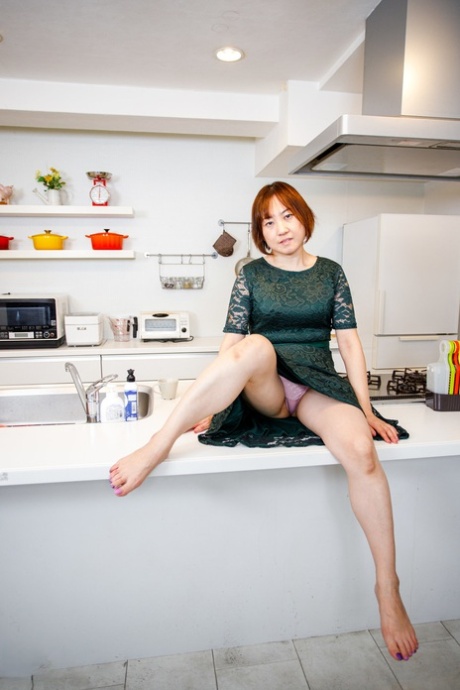 Asian housewife Yuki Kozakura shows her shaved pussy in the kitchen