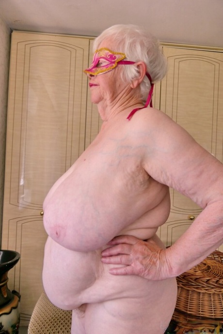 Playful granny Zizoresta puts a mask on before showing her huge saggy tits