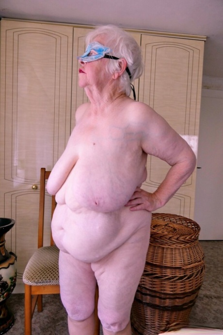 Playful granny Zizoresta puts a mask on before showing her huge saggy tits