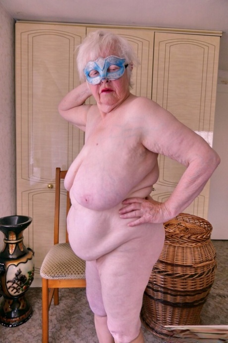 Playful granny Zizoresta puts a mask on before showing her huge saggy tits